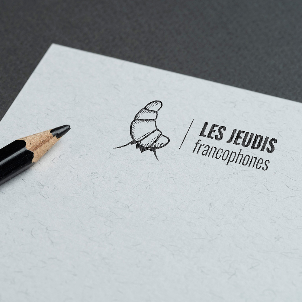 drawing in black pencil on a white sheet of a proposed logo for French-speaking Thursdays with a crescent balanced on Swiss mountains. Design by beyond frames