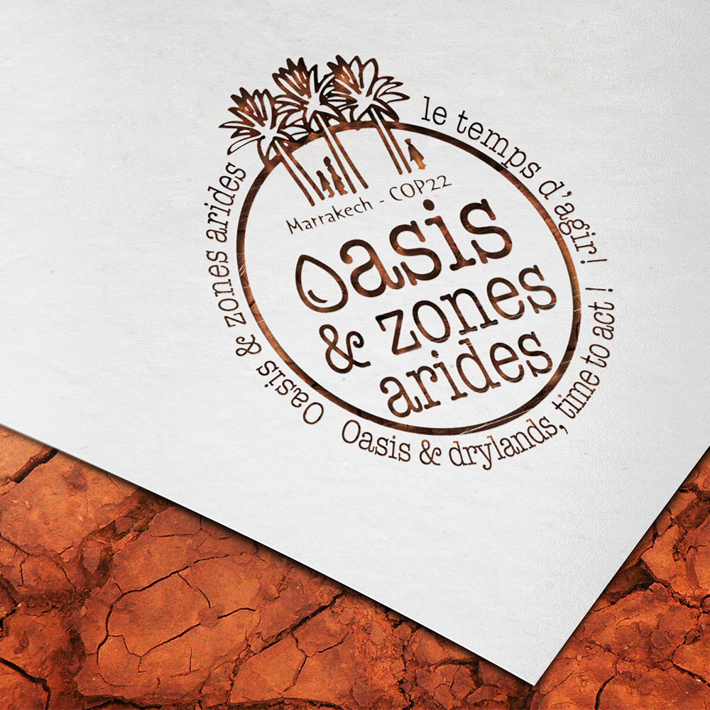 Oasis and arid zones logo laser cut in a white sheet placed on a desert floor. Designed by beyond frames